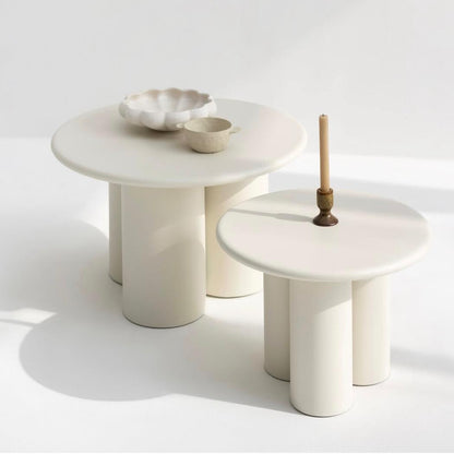 Two white marble side tables with minimal decor on a light background